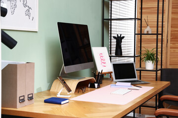 Stylish workplace with modern computer, other devices and stationery on wooden desk indoors