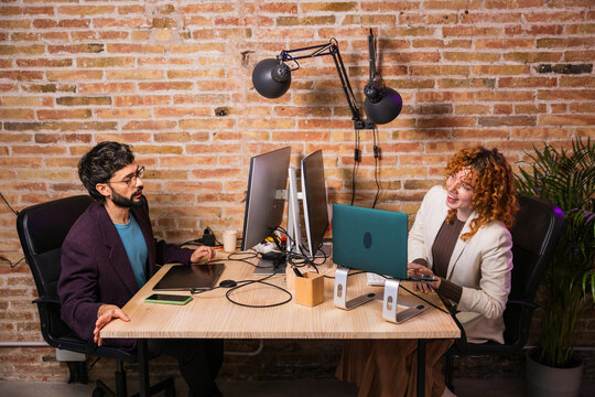 Designers working together at the office using computer and laptop