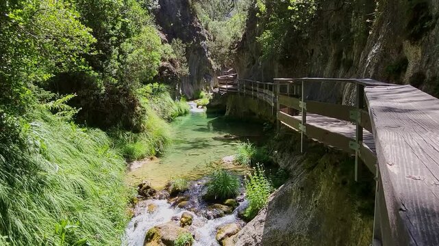 A beautiful turquoise stream inside a gorge with a wooden walkway. Pure waters. Rio Borosa. Cazorla National Park. Spain.