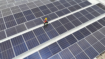 Solar panel worker inspects renewable energy installation on rooftop during daytime