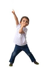 A cheerful 3-year-old boy wearing a white t-shirt and jeans strikes a fun pose while pointing upward and sucking his thumb.