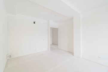 Bright, empty room with white walls and floors. Appears to be unfinished or newly constructed