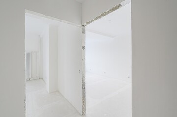 all-white interior shows two open doorways. The space is undergoing renovation or is newly constructed. The light color enhances the feeling of spaciousness