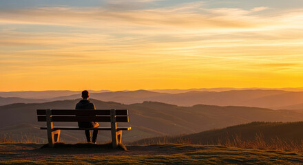 Obraz premium Solitary figure silhouetted on a bench gazing at a majestic mountain sunset