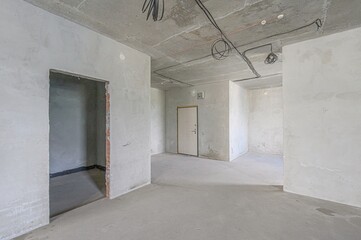 Bare concrete interior with unfinished walls and exposed wiring, typical of construction or renovation phase
