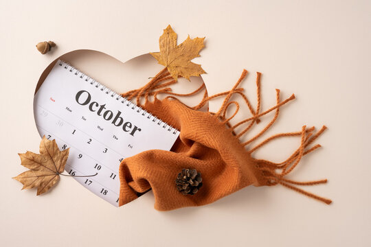 A creatively arranged calendar for October surrounded by autumn leaves, an orange scarf, and seasonal accents. Perfectly embodies the spirit of the fall season with earthy tones and cozy aesthetics