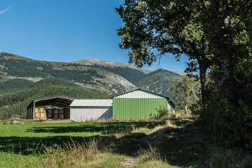 barns of a farm in front of the hills of the French Verdon region