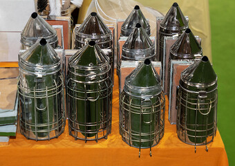 Silver metal bee smoker tool used in beekeeping to calm honey bees generating smoke