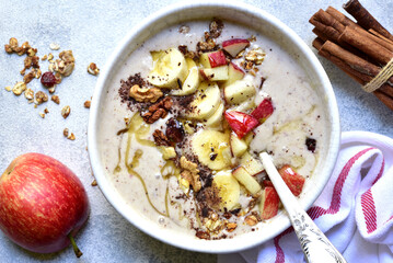 Delicious banana smoothie with apples, nuts and honey in a bowl. Top view with copy space.