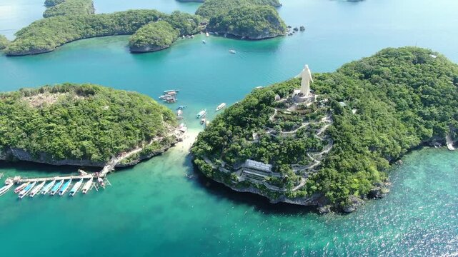 Drone clip of the statue of Jesus Christ on top of pilgrimage island in the hundred islands national park  Philippines .