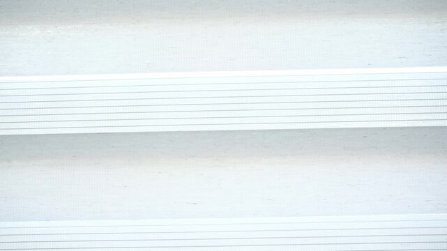 A bright white and light gray surface presents an abstract background. Many horizontal parallel lines create a clean modern textured pattern.