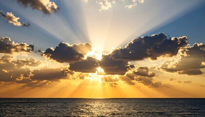 Vibrant sunset over calm ocean, sun rays pierce clouds
