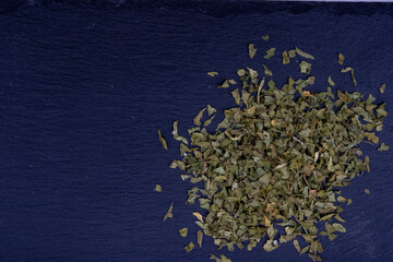 perejil seco y picado sobre una piedra de pizarra negra