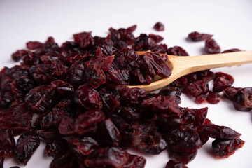 Dried cranberries on wooden spoon on a white background. Healthy eating.