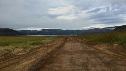 Dirt road leading into misty Icelandic valley