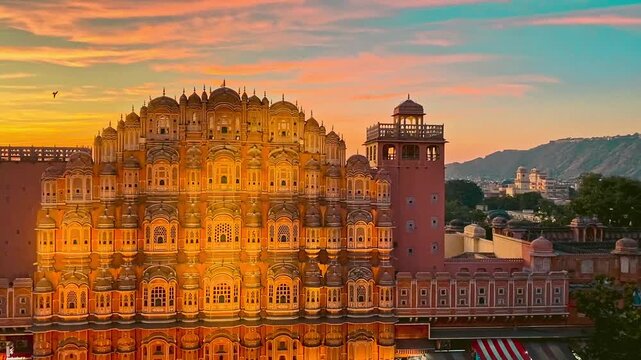 Hawa Mahal in Jaipur, India, is a stunning pink sandstone palace known for its unique honeycomb facade and intricate latticework windows.
