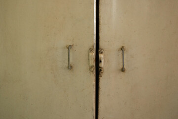 Old kitchen cabinet doors with white paint and iron handles in an apartment