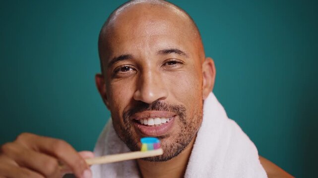 Man brushing teeth. Man holding tooth brusher in front of the mirror.