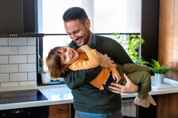 Affectionate single dad enjoy chatting with little son tell about passed day, having fun together