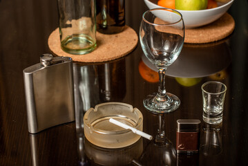 Cigarette in ashtray and cigarette lighter on a dark background