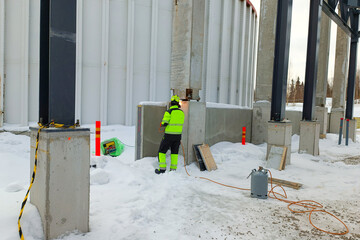 A worker in protective clothing and a helmet carries out fire work at a construction site