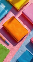Fototapeta premium Colorful notebooks and a pen on a pastel background