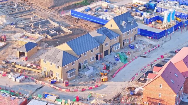 High-resolution static drone shot capturing newly built houses, construction materials, and active groundwork on a modern housing development site in Wombwell, South Yorkshire, England.