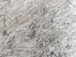 A close-up shot of a rough, gray, and white textured surface, possibly a wrinkled fabric, crushed paper, or a distressed wall.