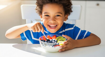 Adorable african american boy eating healthy fruit and yogurt breakfast. Happy kid enjoying nutritious meal at home.