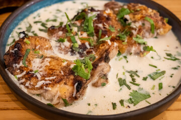 Shkmeruli is a traditional Georgian dish from Racha region. Chicken is pan fried and then simmered in a creamy garlic sauce, served hot. 