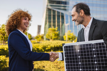 Businesspeople shaking hands over solar panel investment