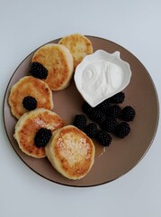 Syrniki with cottage cheese and blackberries. Healthy breakfast.