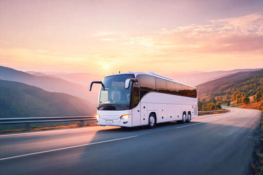 A white, modern, luxury coach bus driving on a highway road in a beautiful natural landscape at sunset, commercial photography