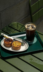 Icy coffee glistens beside quirky lattice pastries on a verdant table, perfect for Danish Fika or Korean Pepero Day