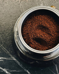 Richly aromatic coffee grounds in a silver tin evoke morning rituals, Caffeine Awareness Month, and the Danish Hygge philosophy