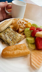 A tantalizing breakfast palette of crispy churro, tangy fruits, and savory omelet evokes Carnival de Barranquilla's lively festivities