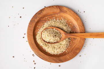Hemp seeds in wooden spoon and bowls on light background. Superfood, healthy tasty organic hemp seeds, source of omega 3, protein, flat lay top view. Supplement to healthy diet