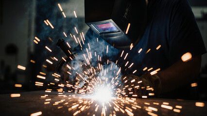 Welder with mask and sparks flying 
