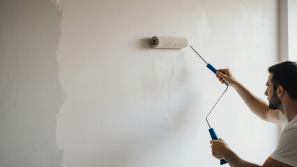 Painter using roller on indoor wall 
