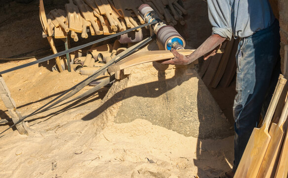 A worker carves an unfinished cricket bat at sports manufacturing factory in Meerut, a largest sports manufacturer, producer of sports gear and equipment.