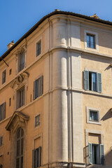 Windows on a yelow building overlooking Roman streets 