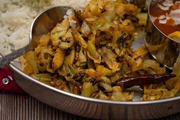 South Indian vegan cabbage curry next to rice and rasam