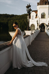 An Elegant Bride is Posing in a Beautiful White Dress at a Scenic Location with Charm