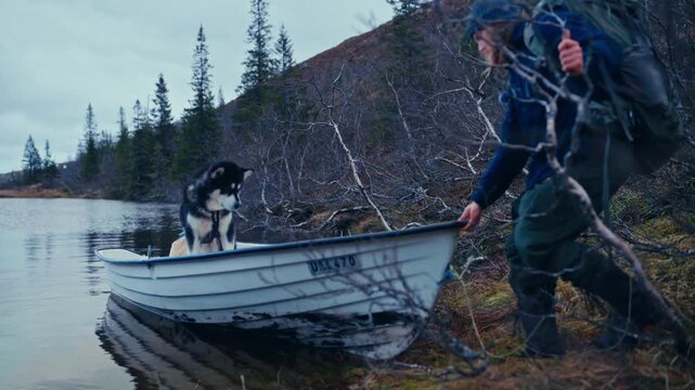 Man And His Alaskan Malamute Dogs In A Boat In &Aring;fjord, Norway - Wide Shot
