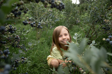 a girl with blonde hair smiles with her lips pressed together