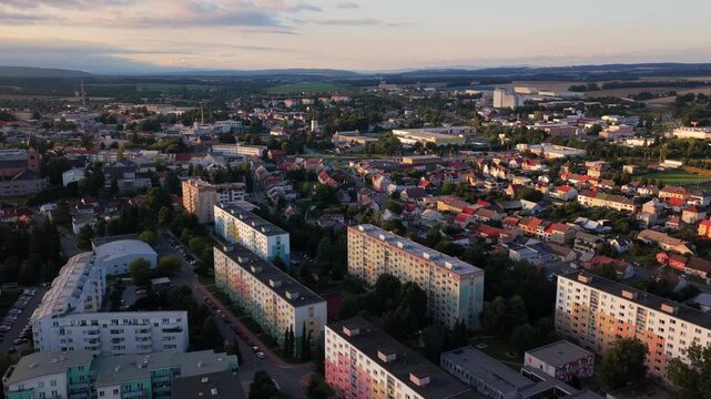 Aerial drone view of the town of Svitavy during a calm evening. Residential apartment blocks are nestled in a peaceful neighborhood, with soft evening light casting long shadows over the quiet streets