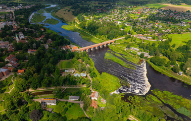 Aerial view on the old red brick bridge and widest waterfall in europe in the summer. City
