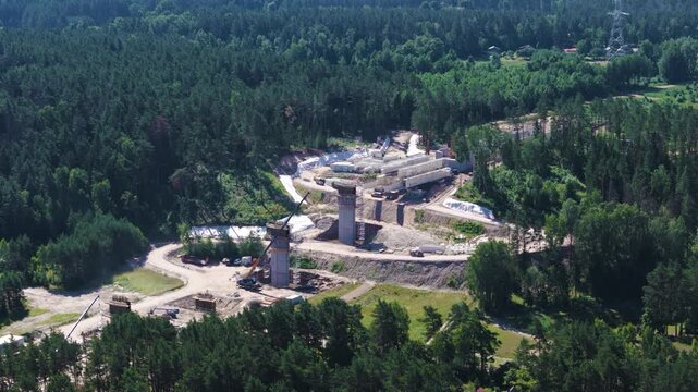 Rail Baltica railway bridge columns surrounded with dense woodland, aerial view