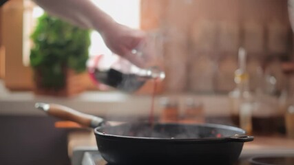 A man pours red wine into a hot, steaming skillet of sauteed vegetables. This deglazing step adds rich flavor to the sauce base. Spices and herbs are blurred in the background - Powered by Adobe
