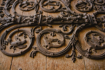 Metal ornament on the wooden door of the Catholic cathedral